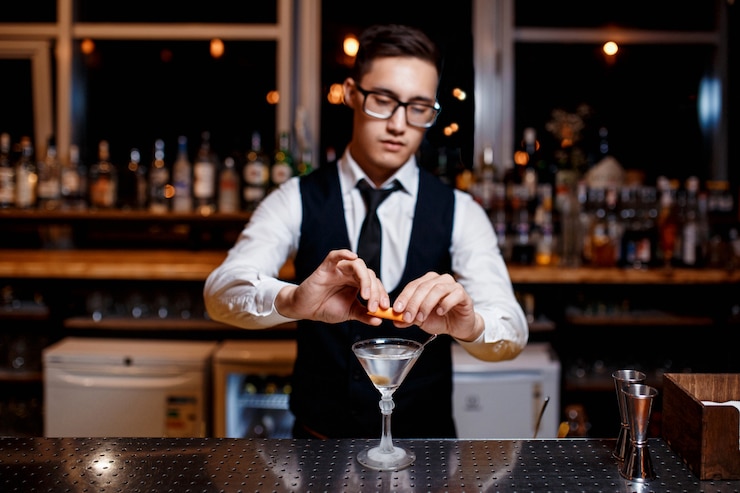 Foto il giovane barista maschio elegante prepara un cocktail delizioso