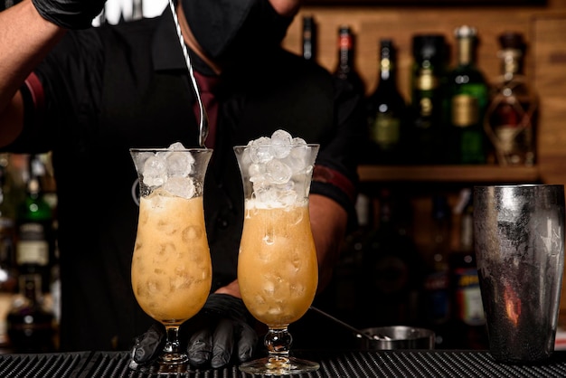 Il giovane barista professionista sta preparando un cocktail per i suoi clienti al lavoro. concetto di professione
