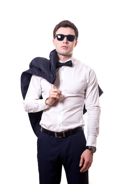 Il giovane bell'uomo bianco in una camicia da ufficio rigorosa si trova isolato su uno sfondo bianco