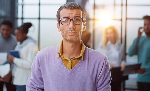 Il giovane bell'uomo in abiti eleganti e occhiali distoglie lo sguardo