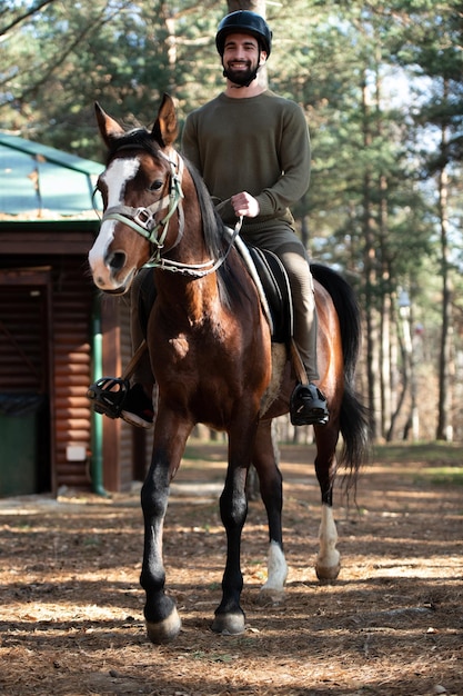 Il giovane cavalca un cavallo che indossa un casco