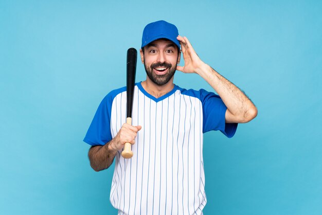 Il giovane che gioca a baseball sul blu isolato ha appena realizzato qualcosa e ha intenzione di risolverlo