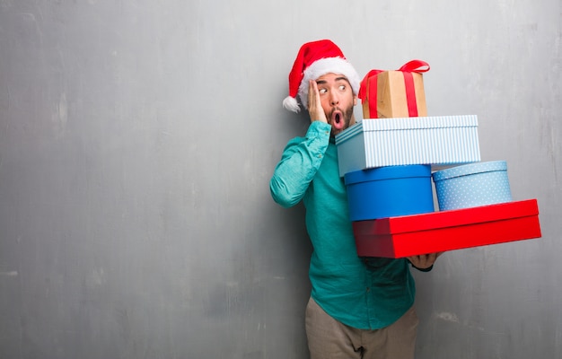 Il giovane che indossa i regali della tenuta del cappello di Santa ha sorpreso e colpito