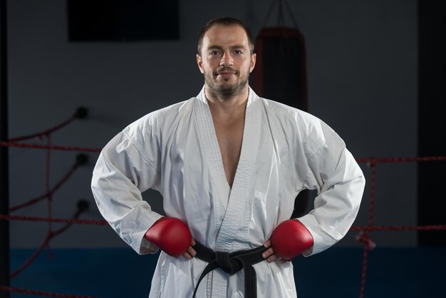 Il giovane che pratica il suo karate muove la cintura nera del kimono bianco