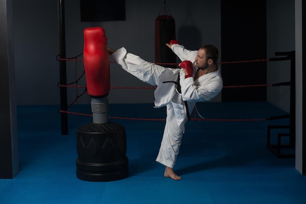 Il giovane che pratica il suo karate muove la cintura nera del kimono bianco