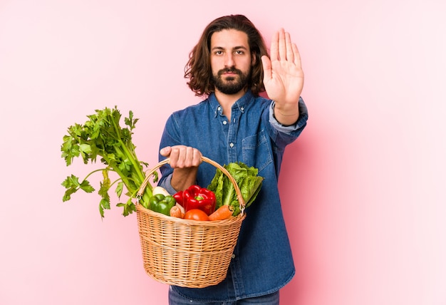 Il giovane che seleziona le verdure organiche dal suo giardino ha isolato la condizione con la mano tesa che mostra il fanale di arresto, impedendovi.