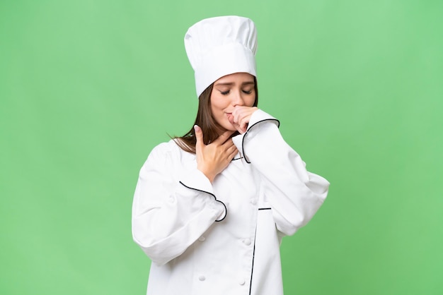 Il giovane chef donna caucasica su sfondo isolato soffre di tosse e si sente male