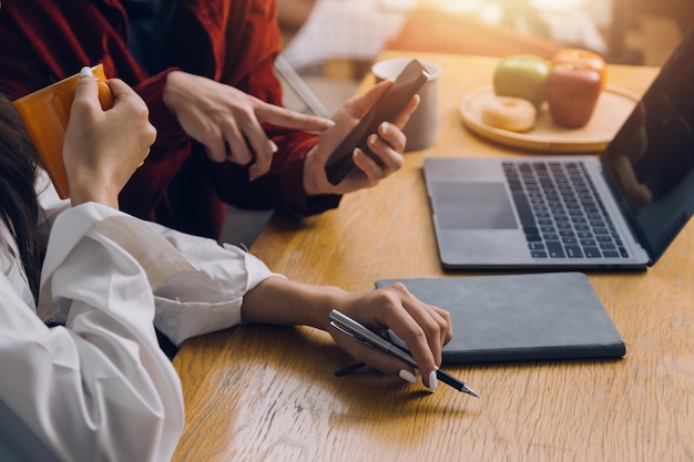 Il giovane collega asiatico presenta e spiega e utilizza il computer portatile in un ufficio