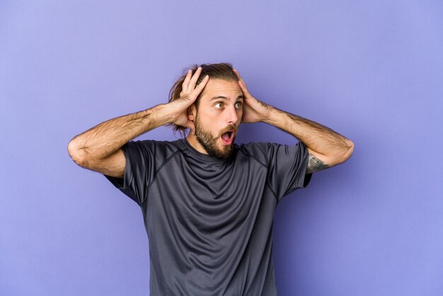 Il giovane con i capelli lunghi guarda urlando, molto eccitato, appassionato, soddisfatto di qualcosa.