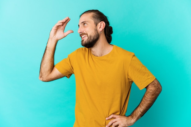 Il giovane con i capelli lunghi sembra gioioso ridendo molto. Concetto di felicità.