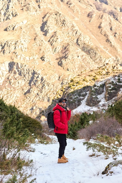 Il giovane con lo zaino vede la vista sulla cima del concetto di viaggio e di vacanza di felicità di libertà della montagna...