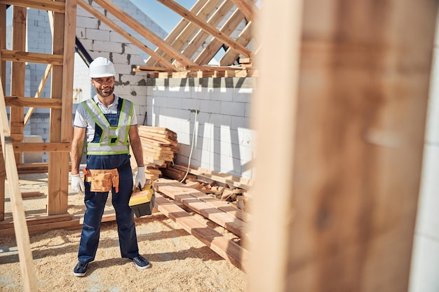 Il giovane costruttore felice positivo è in cantiere