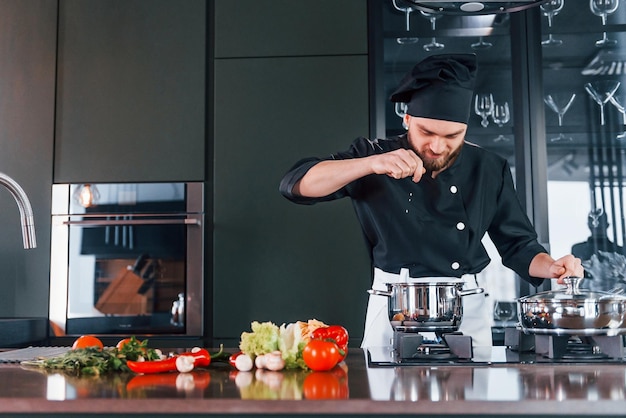 Il giovane cuoco professionista in uniforme ha una giornata impegnativa in cucina