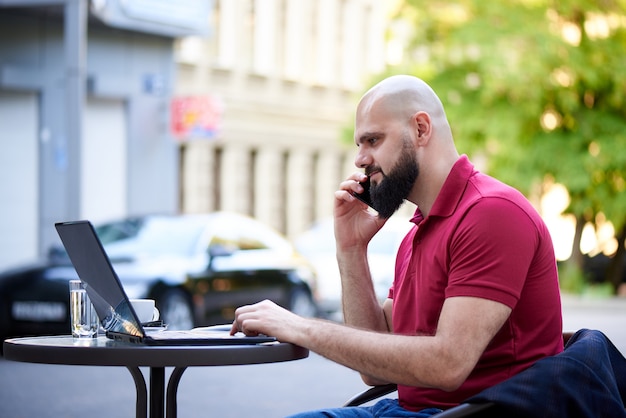 Il giovane di successo lavora in un caffè.