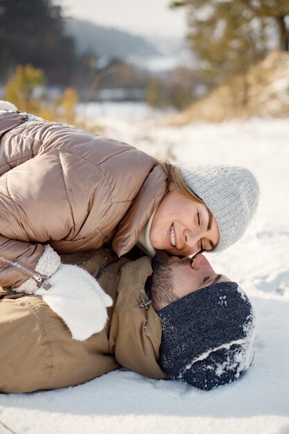 Il giovane e la donna giacevano insieme su una neve al giorno d'inverno