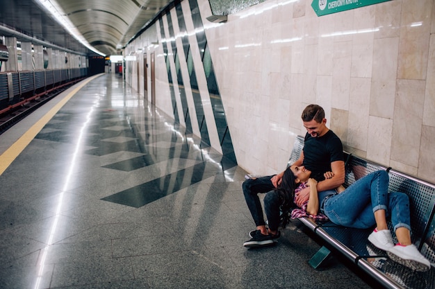 Il giovane e la donna usano la metropolitana. Coppia in metropolitana. Giovane donna sdraiata sul pisolino del ragazzo. La guarda e si abbraccia. Amore a prima vista. San Valentino. Storia d'amore.