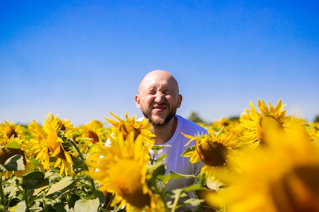 Il giovane fa capolino da un campo di girasoli in una giornata limpida.