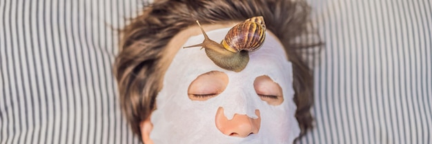 Il giovane fa una maschera facciale con muco di lumaca Lumaca che striscia su una maschera facciale SPA per uomo SPA per tutti