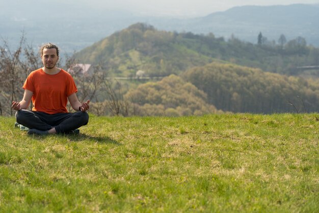 Il giovane fa yoga sul picco di roccia Meditazione