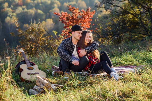 Il giovane felice abbraccia la sua ragazza al picnic nel parco.