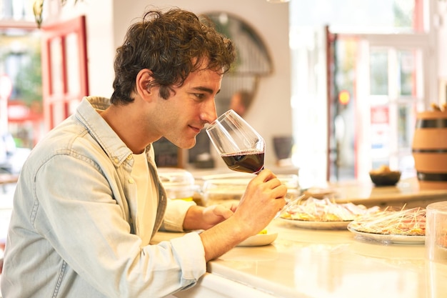 Il giovane gode di una degustazione di vini al bancone del bar