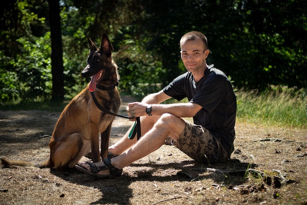 Il giovane hipster caucasico trascorre del tempo con il suo cane nel parco in una soleggiata giornata estiva Il concetto di un animale domestico come membro della famiglia