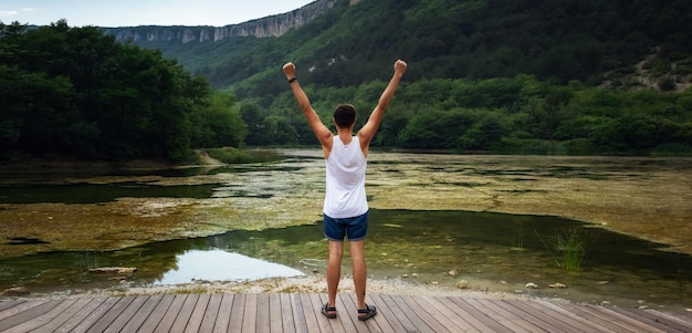 Il giovane hipster maschio guardando la splendida vista sul lago