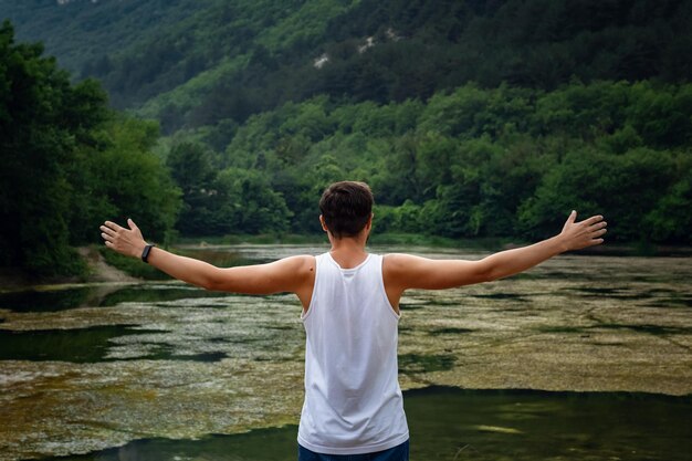 Il giovane hipster maschio guardando la splendida vista sul lago