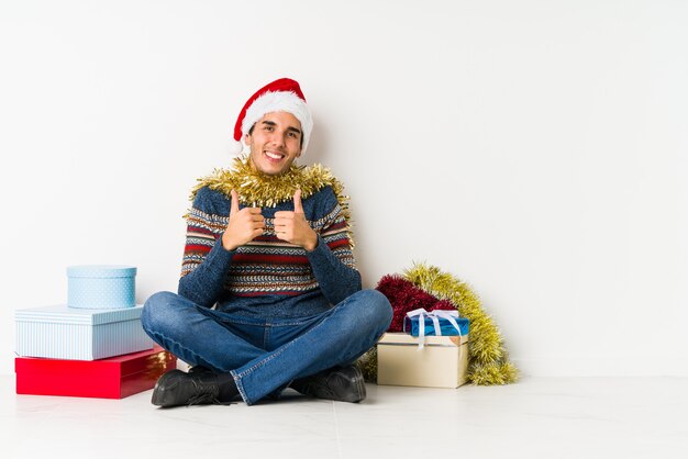 Il giovane il giorno di Natale che mostra bene firma sopra gli occhi