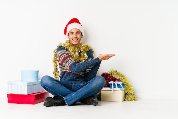 Il giovane il giorno di Natale sembra da parte sorridente, allegro e piacevole.