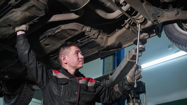 Il giovane impiegato controlla il fondo dell'automobile rotto alla stazione