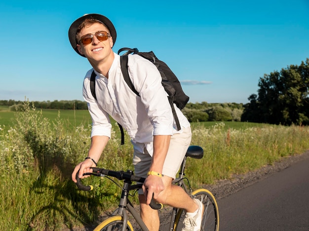 Il giovane in bianco ama andare in bicicletta