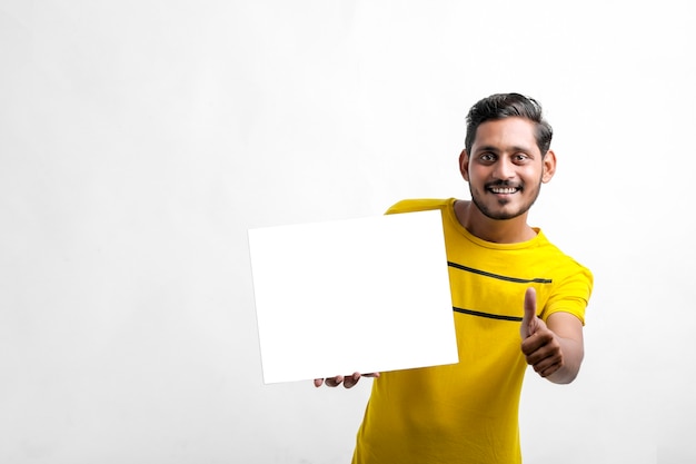 Il giovane indiano che mostra il bordo bianco canta su sfondo bianco