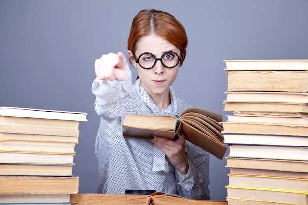 Il giovane insegnante in bicchieri con libri.