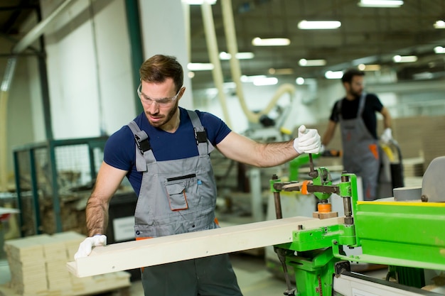 Il giovane lavora in una fabbrica per la produzione di mobili