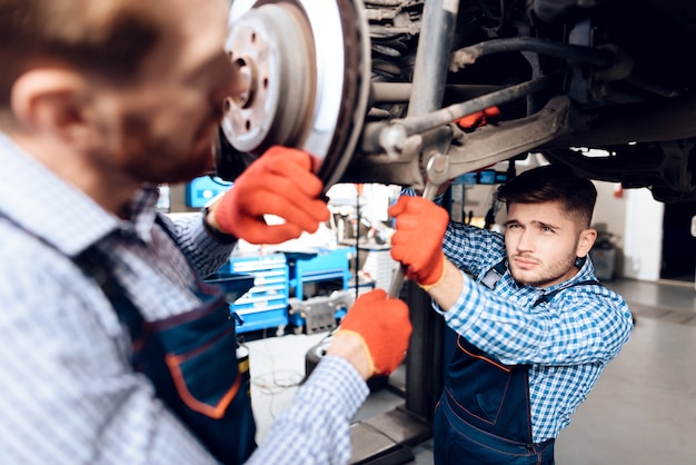 Il giovane meccanico ripara l&#39;hub automobilistico in garage.