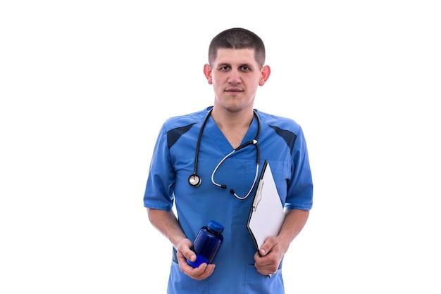 Il giovane medico in uniforme blu prende le pillole dai barattoli isolati su fondo bianco