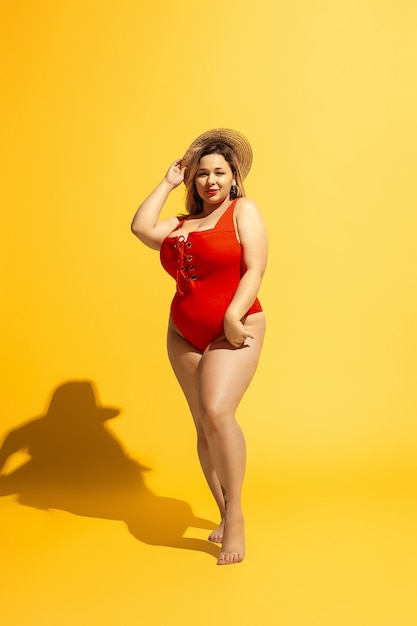 Il giovane modello femminile caucasico plus size si sta preparando per il resort sulla spiaggia