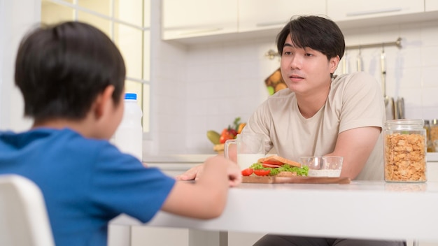 Il giovane padre asiatico ha fatto arrabbiare suo figlio per aver mangiato verdure in cucina a casa