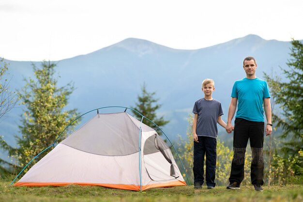 Il giovane padre e il figlio di suo figlio fanno un'escursione insieme in montagna d'estate. Famiglia attiva in campeggio.