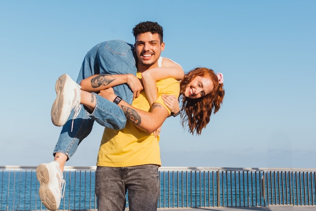 Il giovane porta la sua ragazza sulla schiena divertendosi