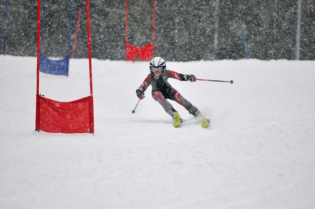 il giovane sciatore corre veloce in discesa nella scena della neve invernale