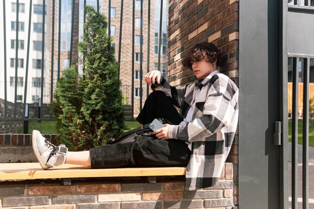 Il giovane si siede rilassato su una panchina della città