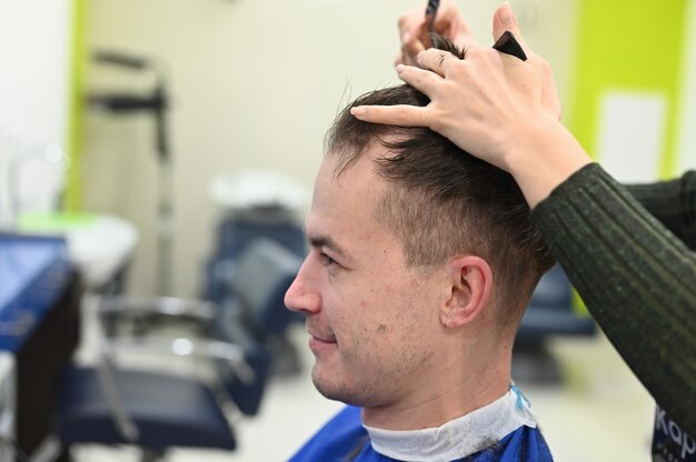 Il giovane si tagliò i capelli dal parrucchiere. taglio di capelli dal parrucchiere. Barbiere