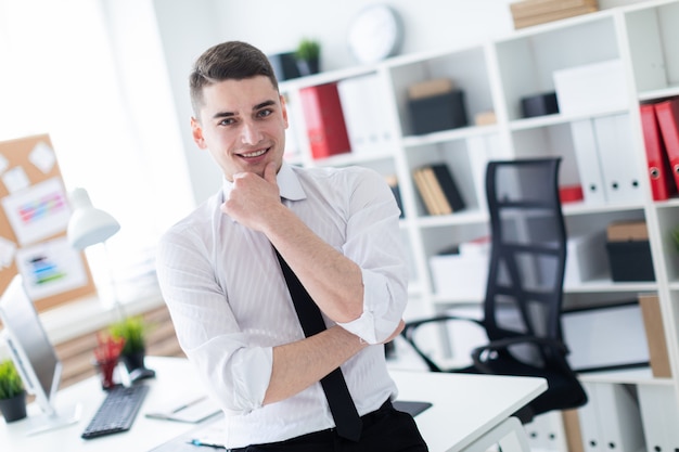 Il giovane si trova in ufficio appoggiato al tavolo.