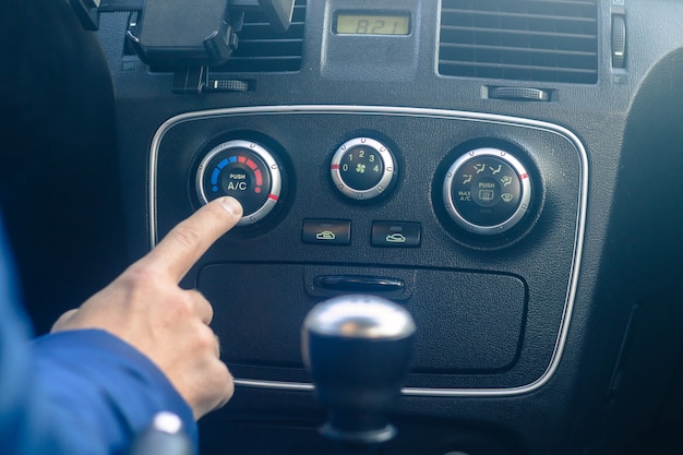 Il giovane sta accendendo il sistema di aria condizionata dell'auto