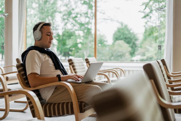 Il giovane studente di college maschio utilizza la videochiamata del laptop online