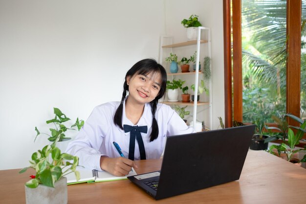 Il giovane studente studia a casa con il computer portatile