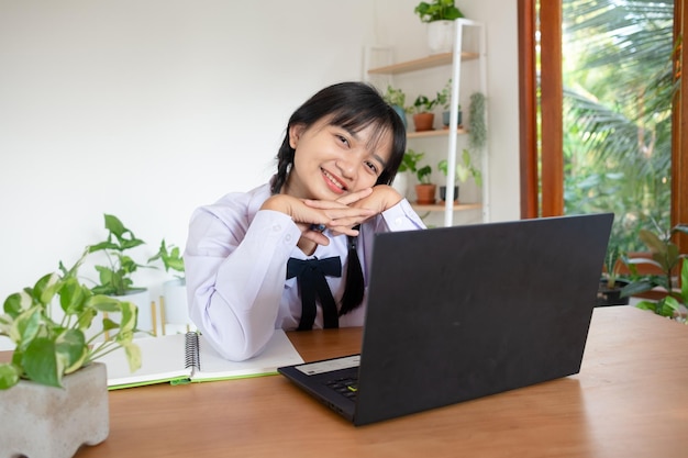 Il giovane studente studia a casa con il computer portatile