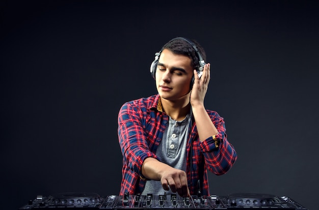 Il giovane suona musica sul mixer di un DJ in studio